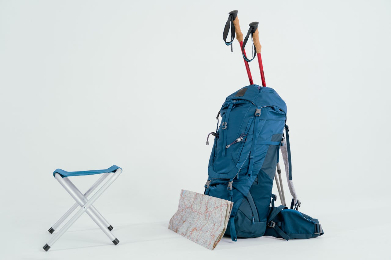 Essential hiking gear including backpack, map, and trekking poles ready for adventure.